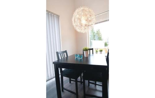 a dining room table with chairs and a chandelier at Beautiful Home In Gotlands Tofta in Västergarn