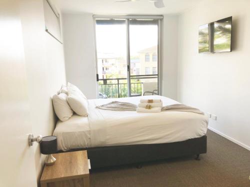 1 dormitorio con 1 cama y ventana en 3 Bedroom Central Beachside Kingscliff Apartment with Pool, en Kingscliff