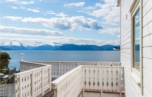 a balcony with a view of the water and mountains at 5 Bedroom Amazing Home In Strandebarm in Strandebarm