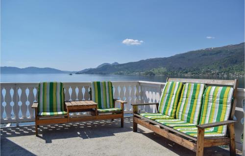 two chairs on a balcony with a view of the water at 5 Bedroom Amazing Home In Strandebarm in Strandebarm