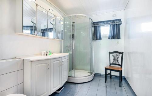 a bathroom with a shower and a sink and a chair at Amazing Home In Strandebarm With House Sea View in Strandebarm