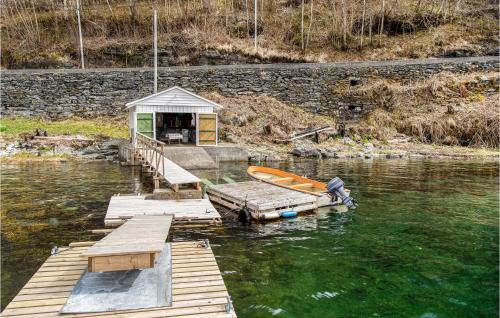 a small dock with a boat on the water at 5 Bedroom Amazing Home In Strandebarm in Strandebarm