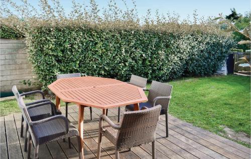 une table et des chaises en bois sur une terrasse en bois dans l'établissement Résidence Les Dunes Du Golf, à Wimereux