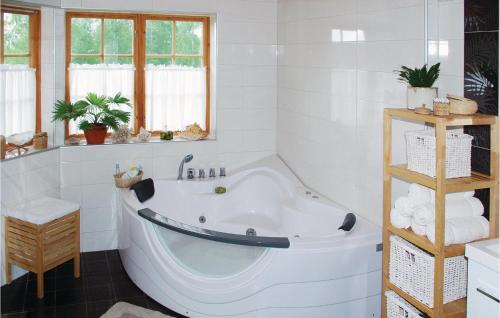 イェルブシェーにあるNice Home In Jrvs With Saunaの白いバスルーム(大型バスタブ付)が備わります。