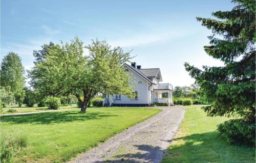 una casa bianca con un albero e una strada sterrata di Beautiful Home In Södra Vi With Wifi a Södra Vi
