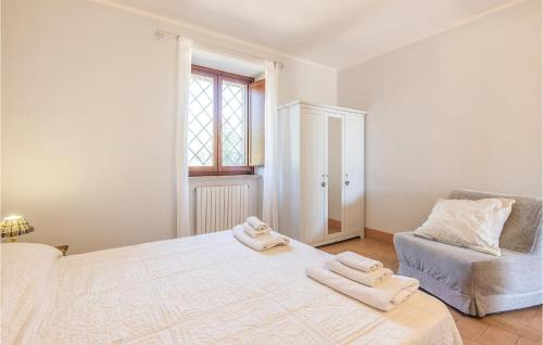 a white bedroom with a bed and a chair at Vista Piscina in Migliano