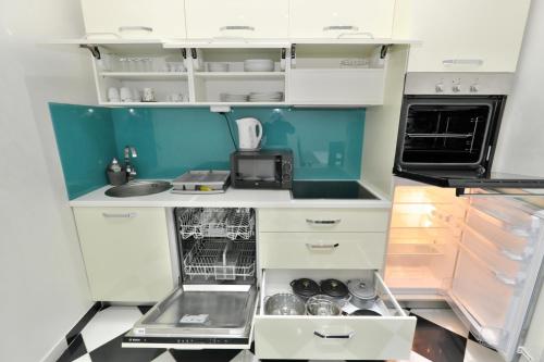 una piccola cucina con armadi bianchi e lavandino di Lux Apartments Prestige a Vienna