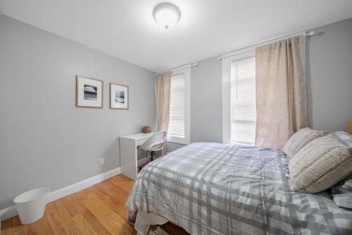 a white bedroom with a bed and a desk at Easy Commute South Boston 4BR 1BH Apt in Boston
