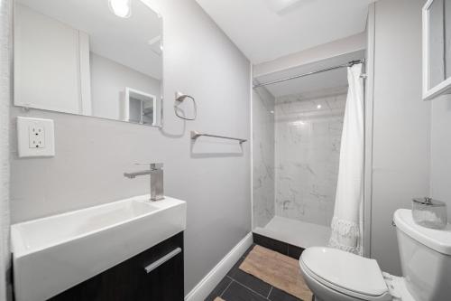 a white bathroom with a sink and a toilet at Easy Commute South Boston 4BR 1BH Apt in Boston