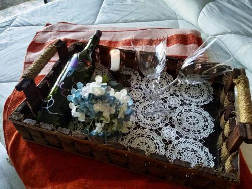 a basket with wine glasses and flowers on a bed at APTO Maison Class - 3 quartos próximo ao shopping in Foz do Iguaçu