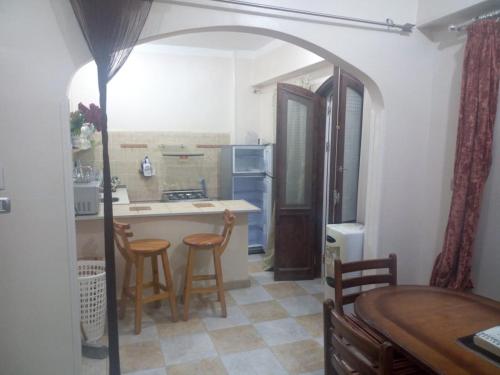 a kitchen with an archway and a table and chairs at Villa Carimo in Quseir