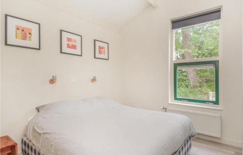 een witte slaapkamer met een bed en een raam bij Royanne in Nunspeet