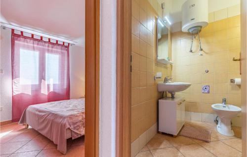 a bathroom with a bed and a sink in a room at 5 Bedroom Cozy Apartment In Banjole in Banjole