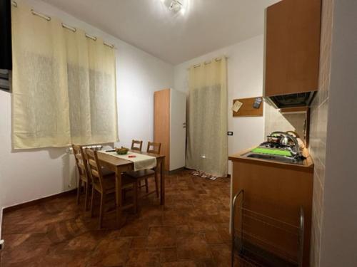 una cucina con tavolo e una cucina con lavandino di OPUNTIA DELL'ETNA BIKE HOUSE a Mascalucia