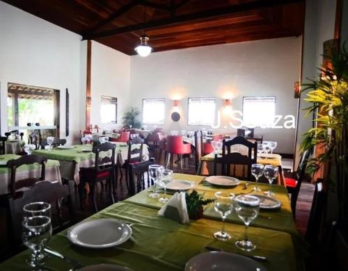 a dining room with tables and chairs with wine glasses at Flat Condomínio Hotel Fazenda Gravatá Monte Castelo in Gravatá