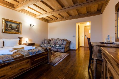 a bedroom with a bed and a couch in a room at Hotel Marysin Dwór in Katowice