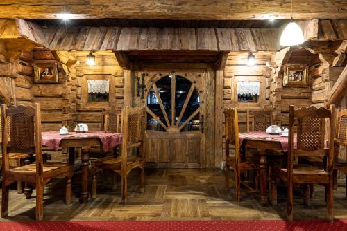 a restaurant with wooden walls and tables and a door at Hotel Marysin Dwór in Katowice