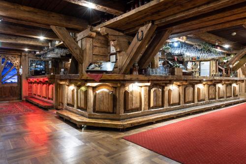 a bar in a room with a red rug at Hotel Marysin Dwór in Katowice