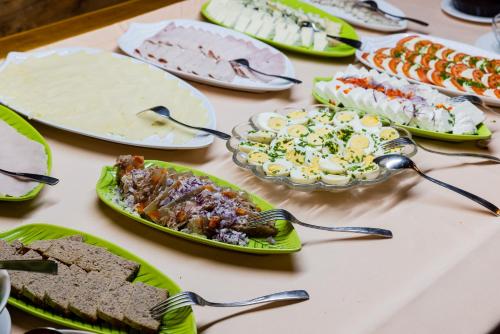 a table topped with plates of food and bowls of food at Hotel Marysin Dwór in Katowice