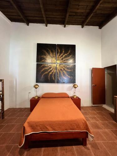 a bedroom with a bed and a painting on the wall at Hotel Hacienda San Bartolo in Xico