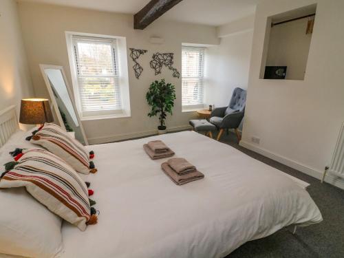 ein Schlafzimmer mit einem großen weißen Bett mit Handtüchern darauf in der Unterkunft Bay Leaf Cottage in Kirkby Stephen