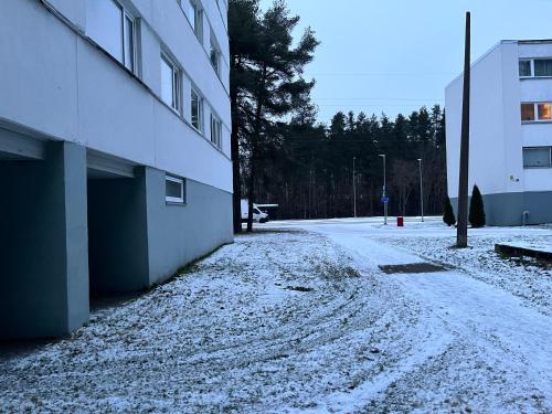 a snow covered street next to a building at Cosy Appartment. Püssi town in Pyussi