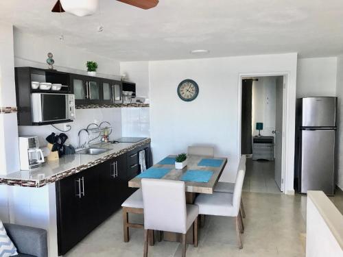 a kitchen and dining room with a table and chairs at Cancun Hotel Zone, Beachfront 2 BR Apartment - Prime Location in Cancún