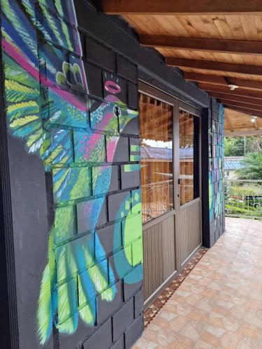 a wall with a painting of a bird on it at Finca Campestre Villa del Campo in Santa Rosa de Cabal