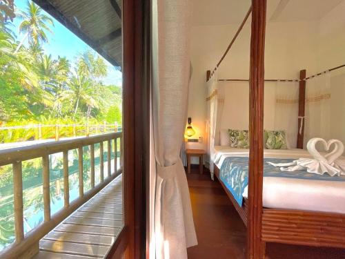 a bedroom with a bed and a balcony at À La Koh Kood Resort in Ko Kood