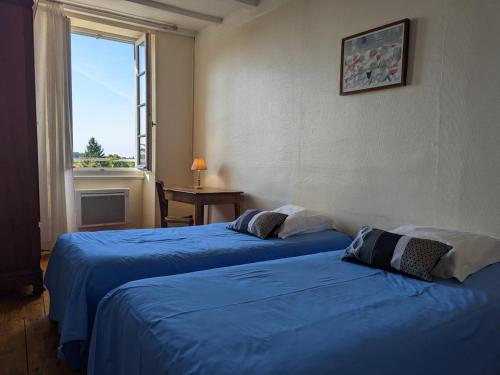 2 camas azules en una habitación con ventana en Gîte Baignes-Sainte-Radegonde, 5 pièces, 7 personnes - FR-1-653-169, en Le Tâtre