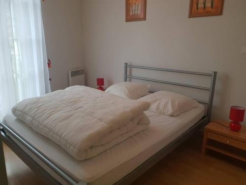 a bed with white sheets and pillows on it at Appartement Cauterets, 3 pièces, 4 personnes - FR-1-234-296 in Cauterets