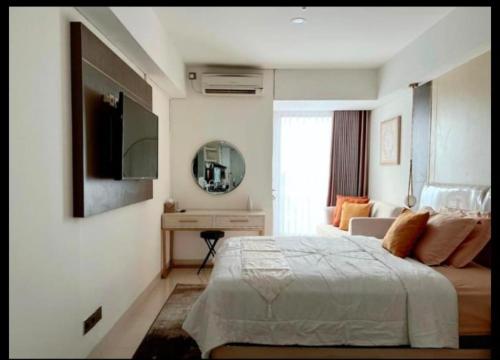 a bedroom with a bed and a desk and a mirror at Cozy apartment in Louis kienne simpanglima in Semarang