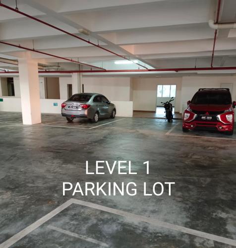 a parking lot with two cars parked in it at Glossy Marina Homestays in Lumut