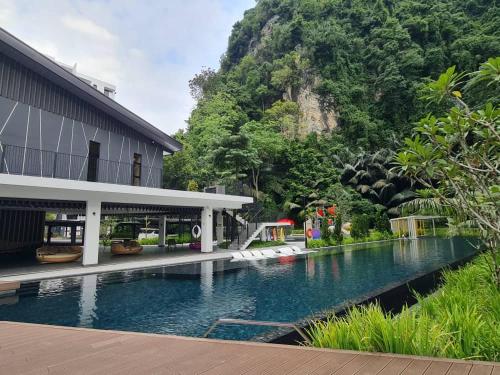 a house with a swimming pool next to a mountain at EG Home - The Cove Hillside Residence in Ipoh