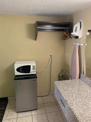 a kitchen with a microwave on top of a refrigerator at Thunderbird Inn in Liberal