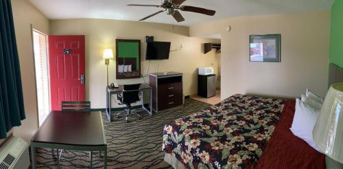 a hotel room with a bed and a red door at Thunderbird Inn in Liberal