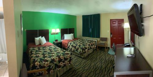 a hotel room with two beds and a flat screen tv at Thunderbird Inn in Liberal