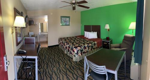 a hotel room with a bed and a green wall at Thunderbird Inn in Liberal