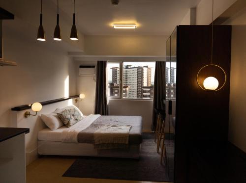 a bedroom with a bed and a window at Stylish Studio @AvidaTowersAtria in Iloilo City