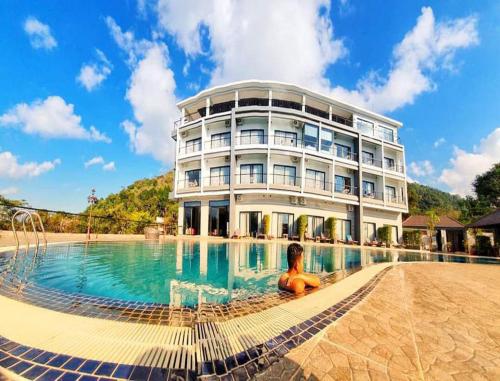 a large building with a swimming pool in front of it at KEP BAY HOTEL & RESORT in Kep