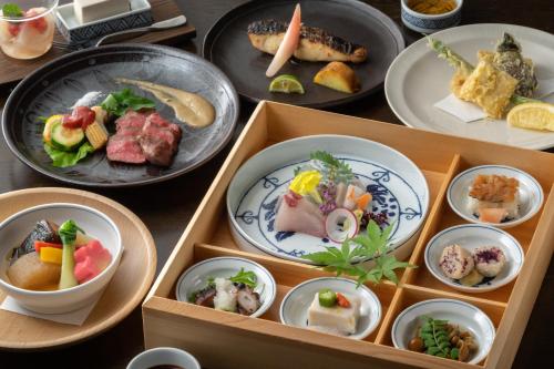 a table with plates of food and bowls of food at Arima Onsen Tocen Goshobo in Kobe