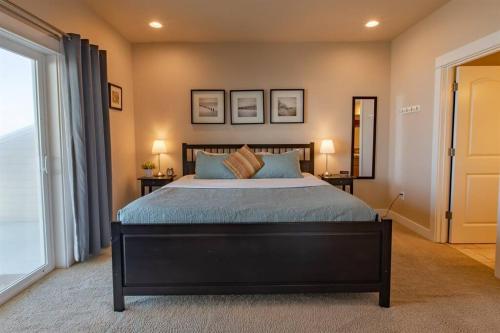 a bedroom with a large bed with blue pillows at Rockaway beach vibes,Waterfront Oceanfront Rockaway Beach House near Downtown,WIFI, Washer Dryer in Rockaway Beach