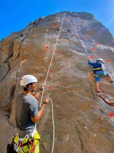 a man and two children on a rock wall at Al Misfah Hospitality Inn in Misfāh