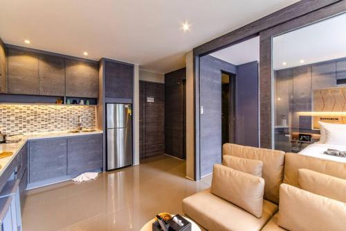 a living room with a couch and a kitchen at Kamala Beach P72 Exclusive Junior Suite in Bang Tao Beach