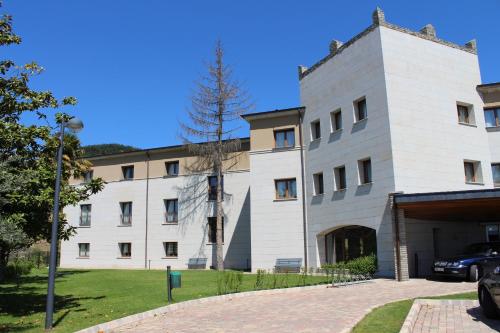 a white building with a car parked in front of it at Parador de Villafranca del Bierzo in Villafranca del Bierzo