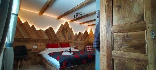 una camera con letto e parete in legno di B&B Le Fió a Valtournenche