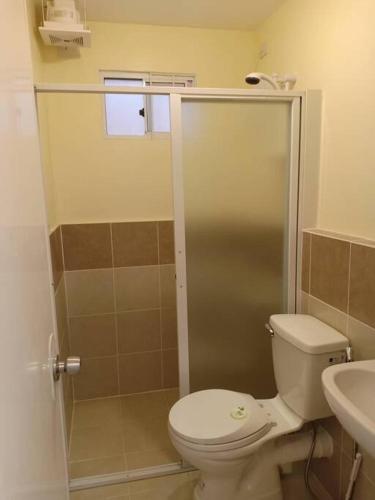 a bathroom with a toilet and a sink at Italian Inspired Tropical-Themed Studio Condo in Davao City