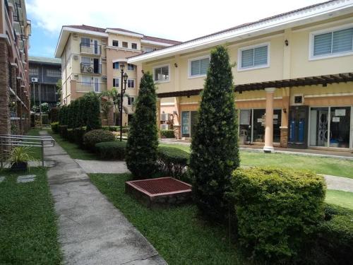 a park with trees and a bench in front of a building at Italian Inspired Tropical-Themed Studio Condo in Davao City
