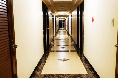 a hallway with tile floors and a long corridor at Italian Inspired Tropical-Themed Studio Condo in Davao City