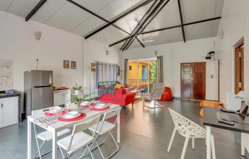 uma cozinha e sala de estar com mesa e cadeiras em Kiki Villa em Arambol